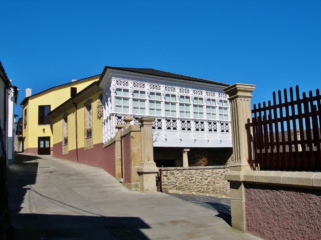 un edificio con una valla al lado de una calle en Mirador Da Ribeira en Viana do Bolo