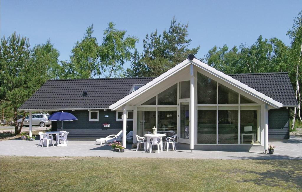 a house with a conservatory with tables and chairs at Holiday Home Bæverstien Denm Iv in Marielyst