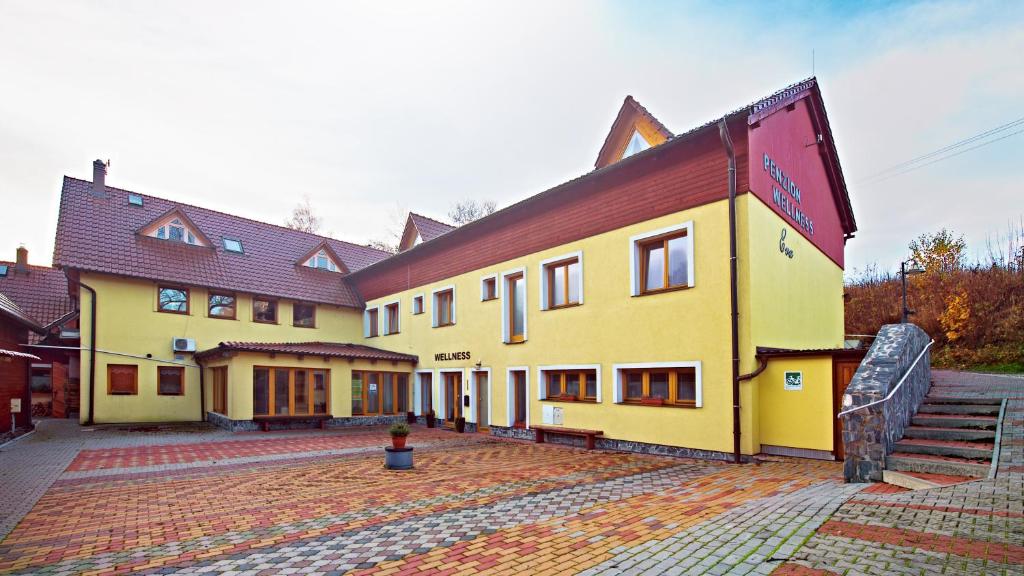 Dolní Moravice的住宿－Wellness Penzion Eva，红色屋顶的大型黄色建筑