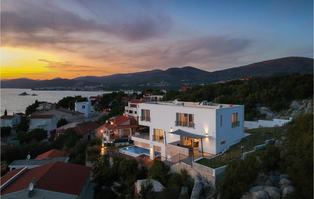 a large white building with a sunset in the background at Stunning Home In Okrug Donji With Sauna, Outdoor Swimming Pool And Heated Swimming Pool in Okrug Gornji