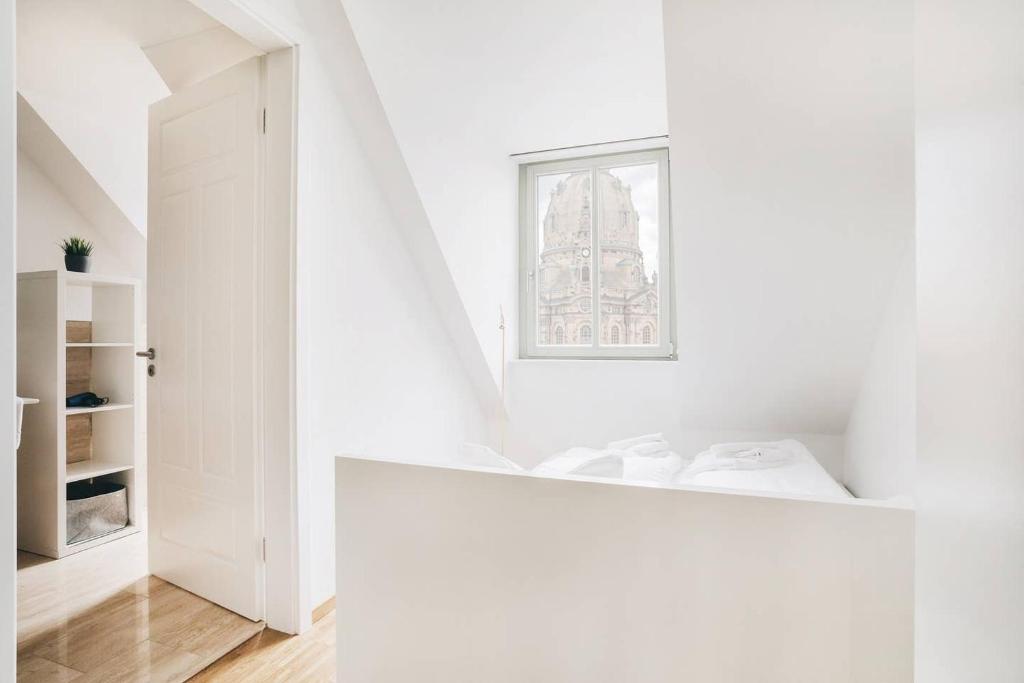 a white room with a bed and a window at Dill Apartment Frauenkirchenblick Dresden in Dresden