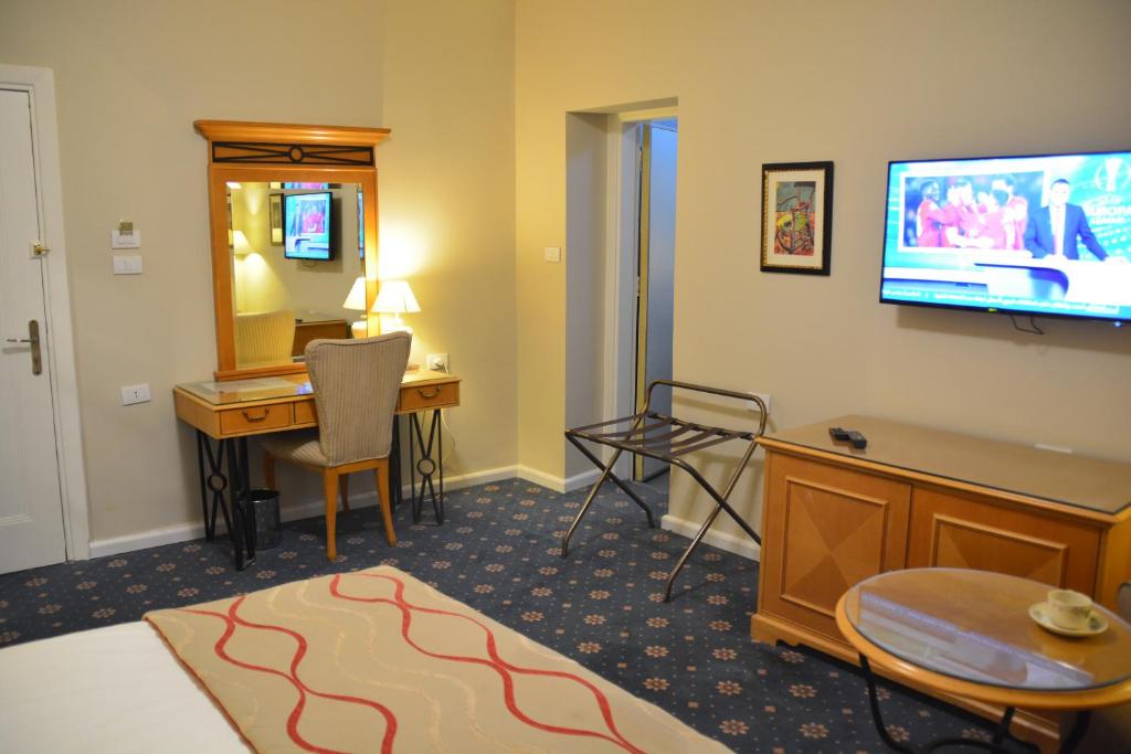 a hotel room with a desk and a television at The Y Hotel in Amman