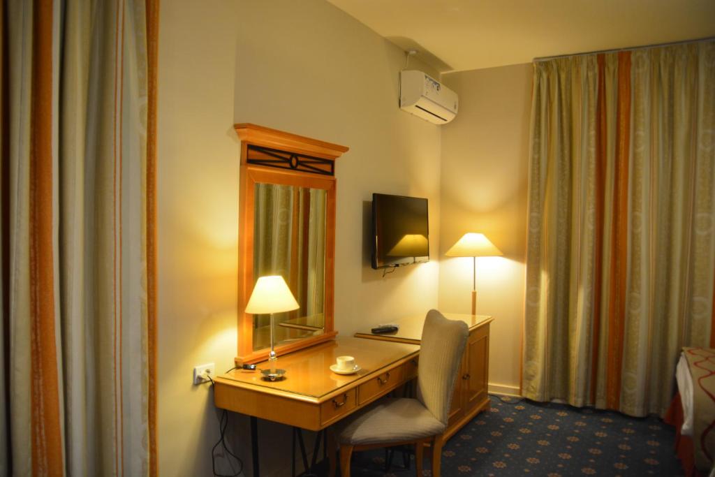 a hotel room with a desk and a mirror at The Y Hotel in Amman