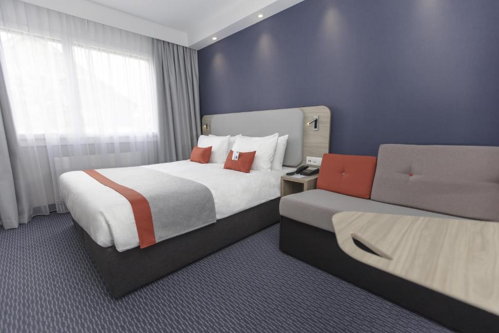 una camera con due letti e un computer portatile di Holiday Inn Express Luzern-Neuenkirch by IHG a Rothenburg
