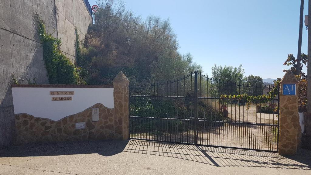 een poort met een stenen hek met een hek bij EL SITIO DE SU RECREO in Jerez de los Caballeros