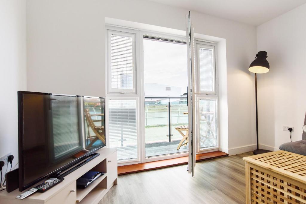 ein Wohnzimmer mit einem TV und einem großen Fenster in der Unterkunft Raphael Retreat in Newport