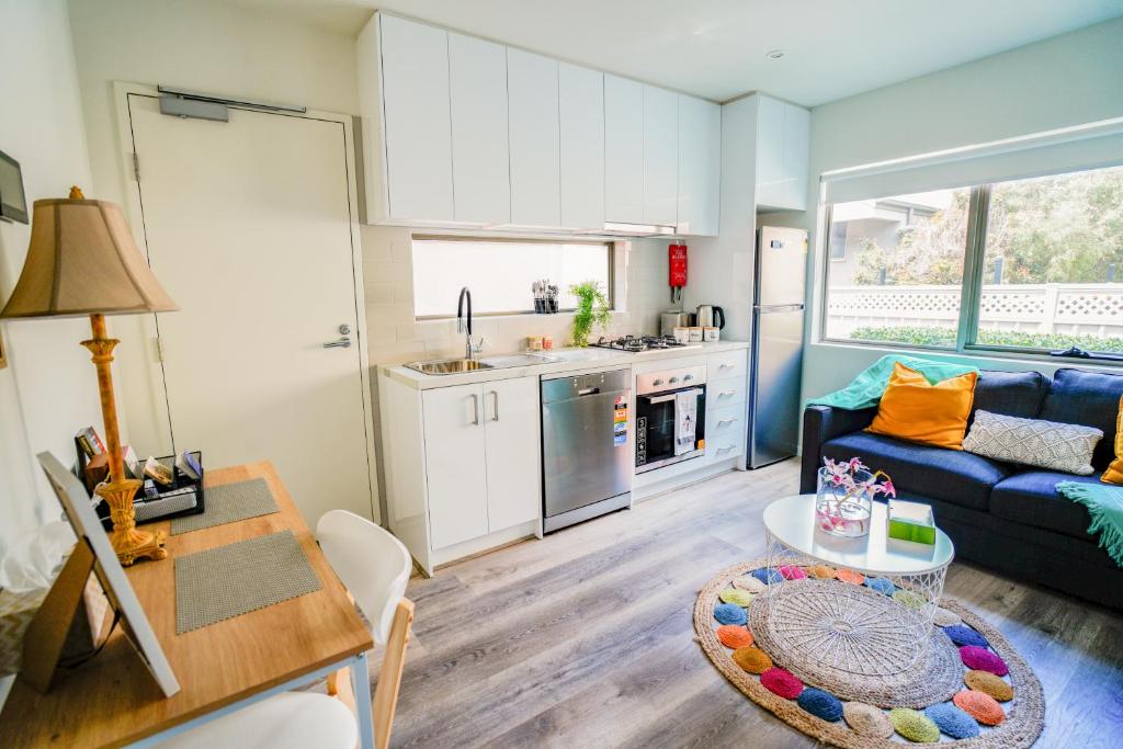 a kitchen and a living room with a couch and a table at U1 Brunswick Living Ground Floor Patio Close to APT and CBD Free Wifi Tram at Doorstep in Melbourne