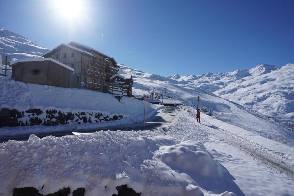 Eine Person geht einen schneebedeckten Berg hinunter in der Unterkunft Le Necou - Reberty 2000 in Les Menuires