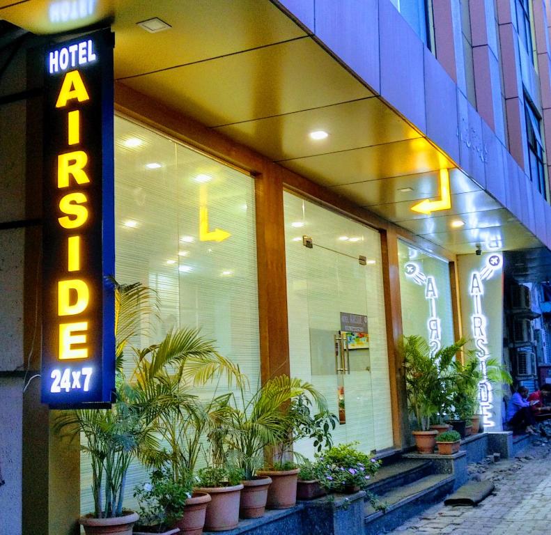 un panneau d'hôtel devant un bâtiment avec des plantes dans l'établissement Hotel Airside, à Mumbai