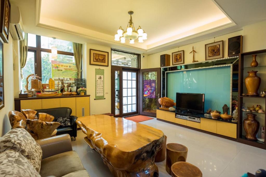馬公市的住宿－美夢居民宿，客厅配有桌子和平面电视。