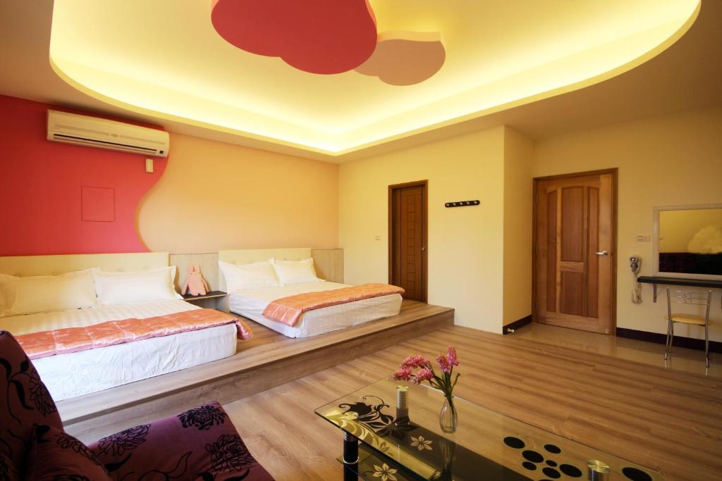 a hotel room with two beds and a tv at Sweet Dream Homestay in Magong