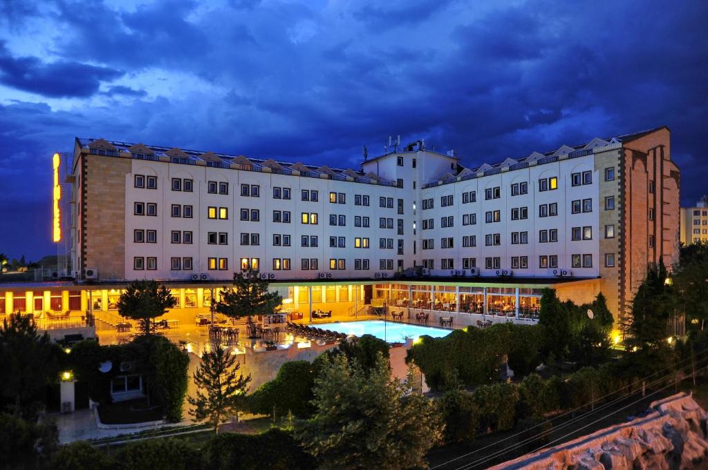 a hotel with a pool in front of a building at Dinler Hotels Urgup in Ürgüp