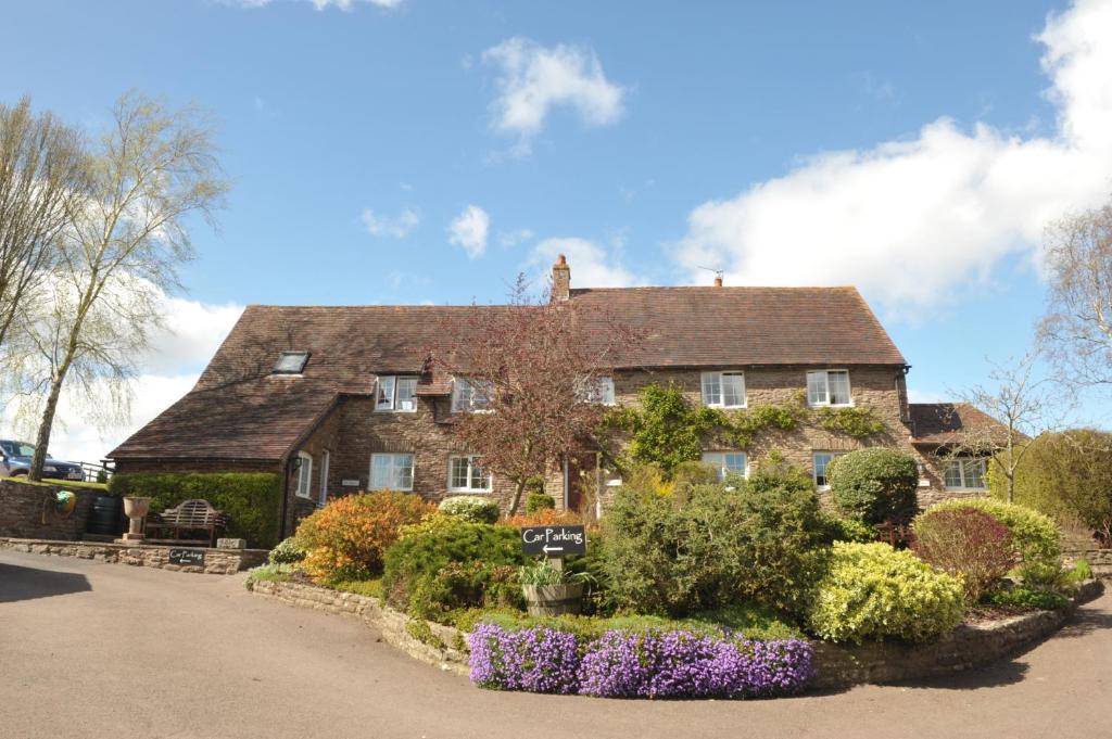 an old house with a garden in front of it at Steppes Farm Cottages in Monmouth