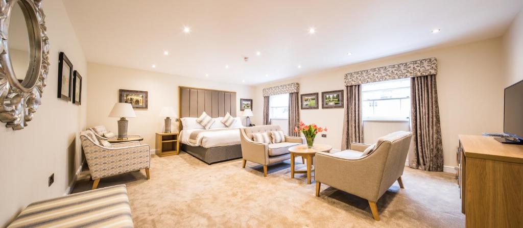 a hotel room with a bed and a living room at The H Boutique Hotel in Bakewell