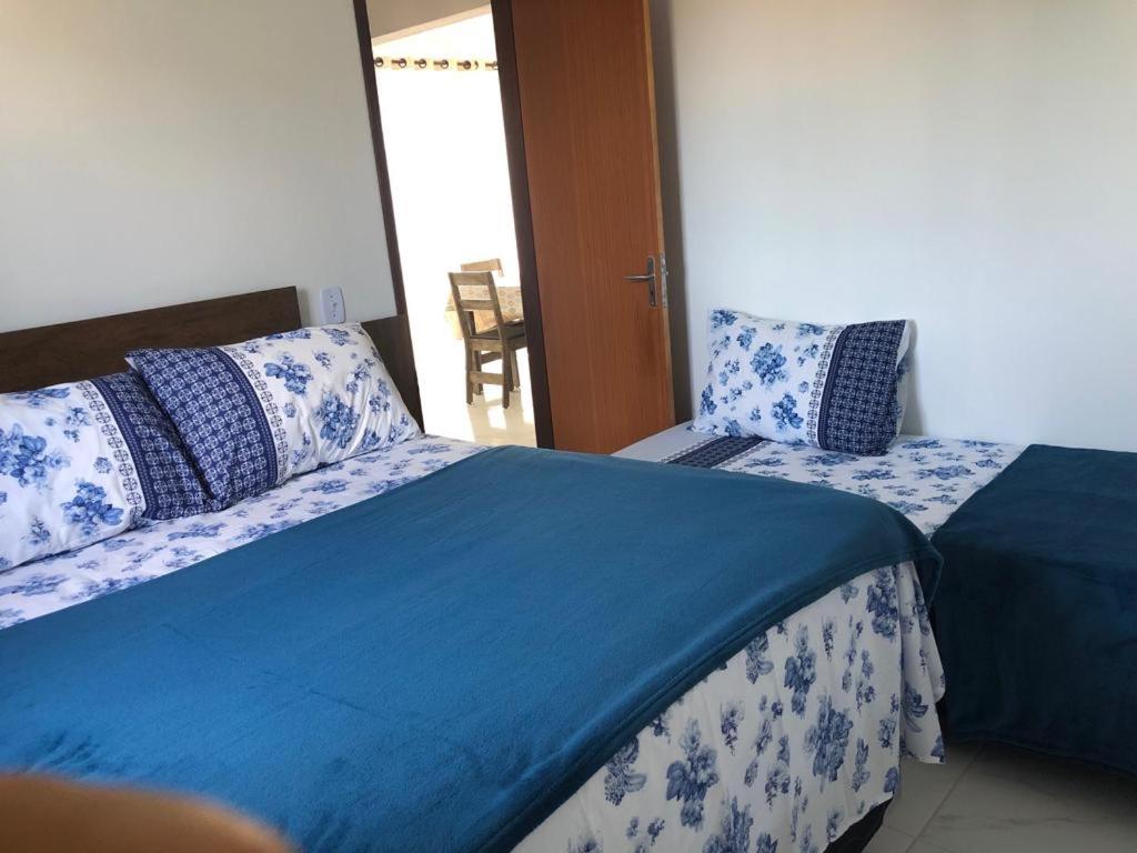 um quarto com duas camas com almofadas azuis e brancas em Porto Cavalinho apartamento 10 em Porto de Galinhas