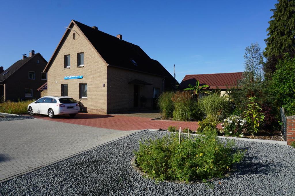 um carro branco estacionado em frente a uma casa em Lilis Ferienwohnung em Munster im Heidekreis