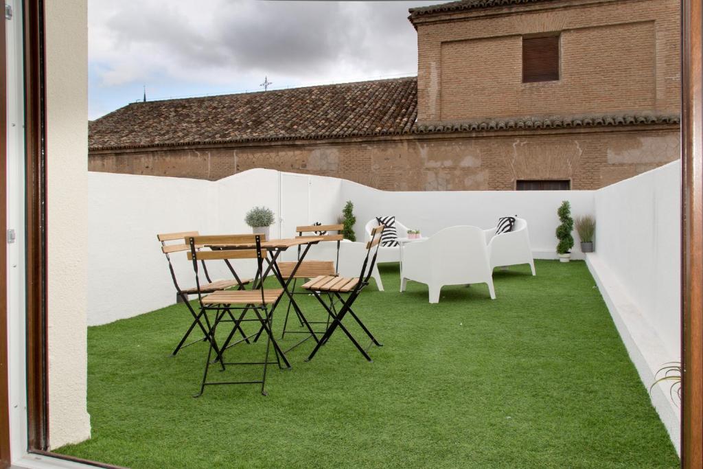 eine Terrasse mit grünem Gras sowie einem Tisch und Stühlen in der Unterkunft Atico San Nicolás in Toledo