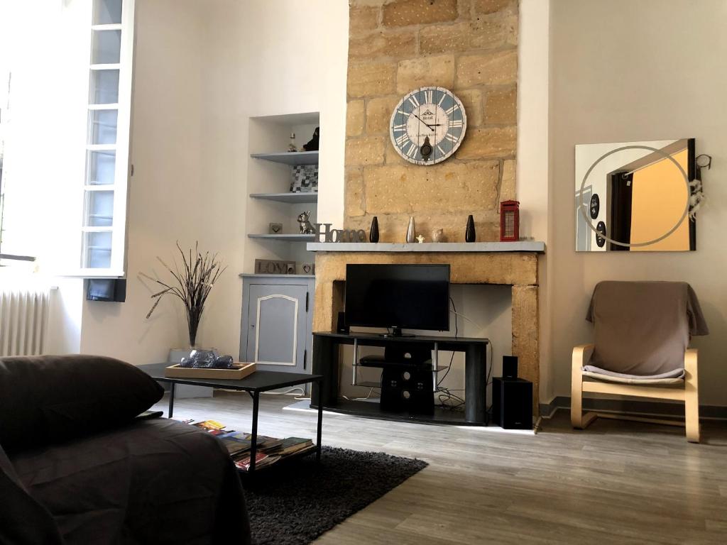 a living room with a tv and a fireplace at L'instant Sarladais in Sarlat-la-Canéda