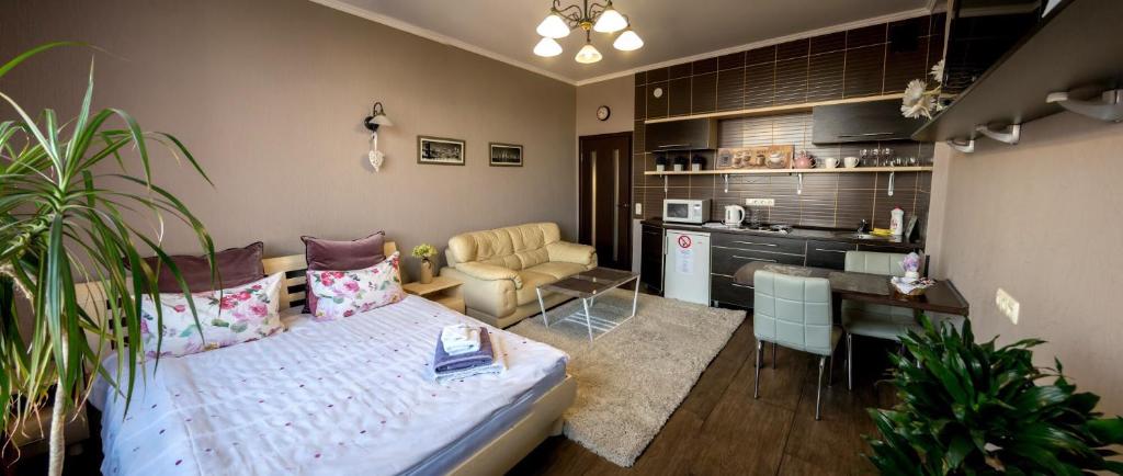 a living room with a bed and a kitchen at Apartment Alla in Chernihiv