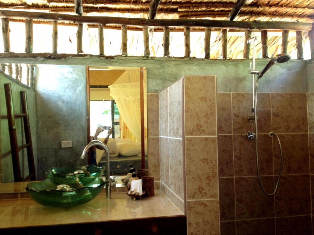 a bathroom with a sink and a shower and a mirror at Nautilus Right on the Beach - Adult Only - SHA Extra Plus in Ko Lanta