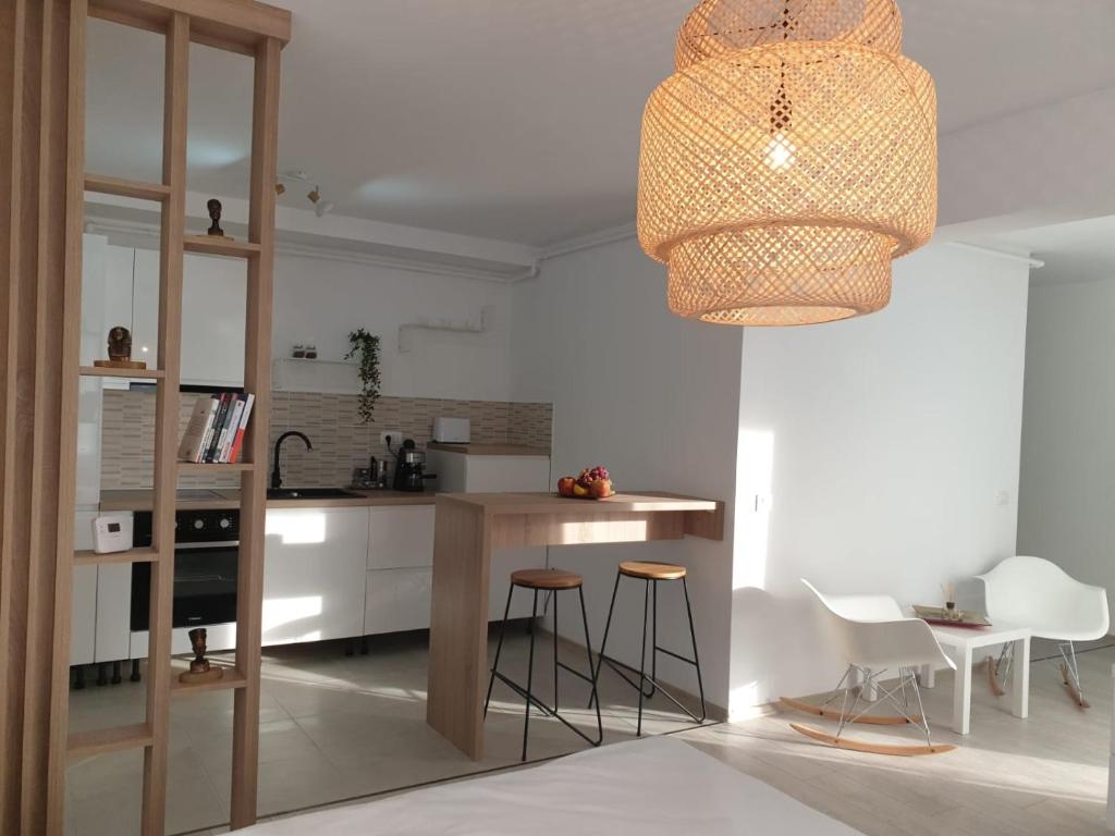 a kitchen with a table and chairs and a chandelier at Suite Life Brasov Coresi in Braşov
