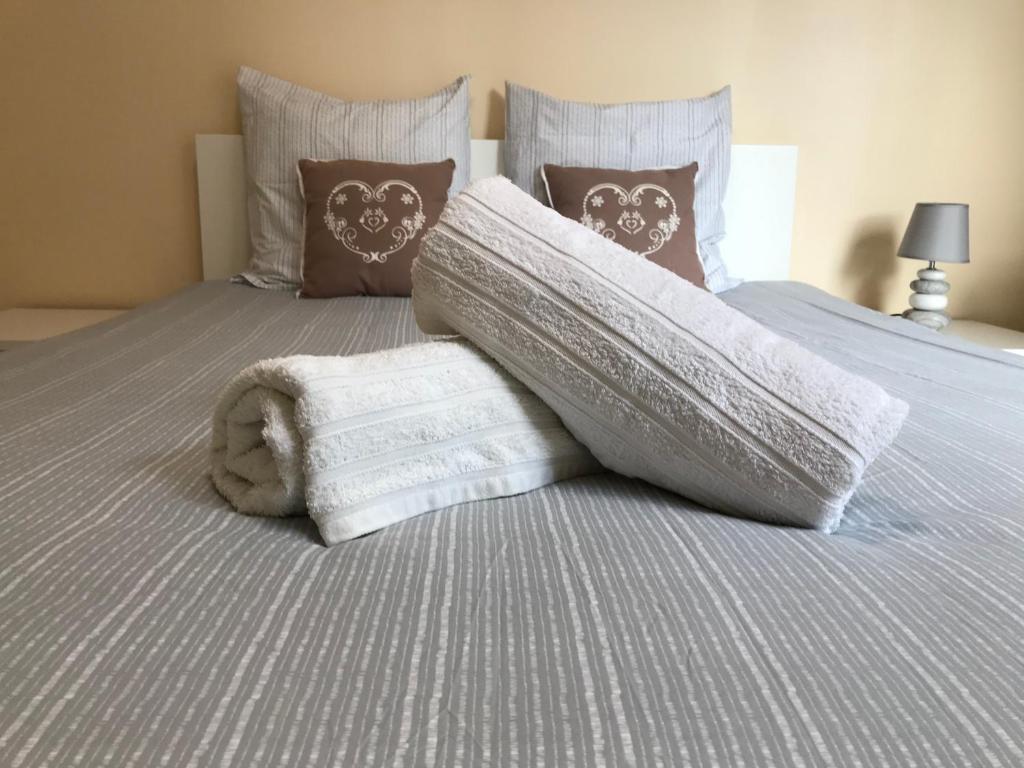 - un lit avec une couverture blanche et des oreillers dans l'établissement Le Victoria, 2p moderne, les pieds dans l'eau, Parking, Piscine, à Menton