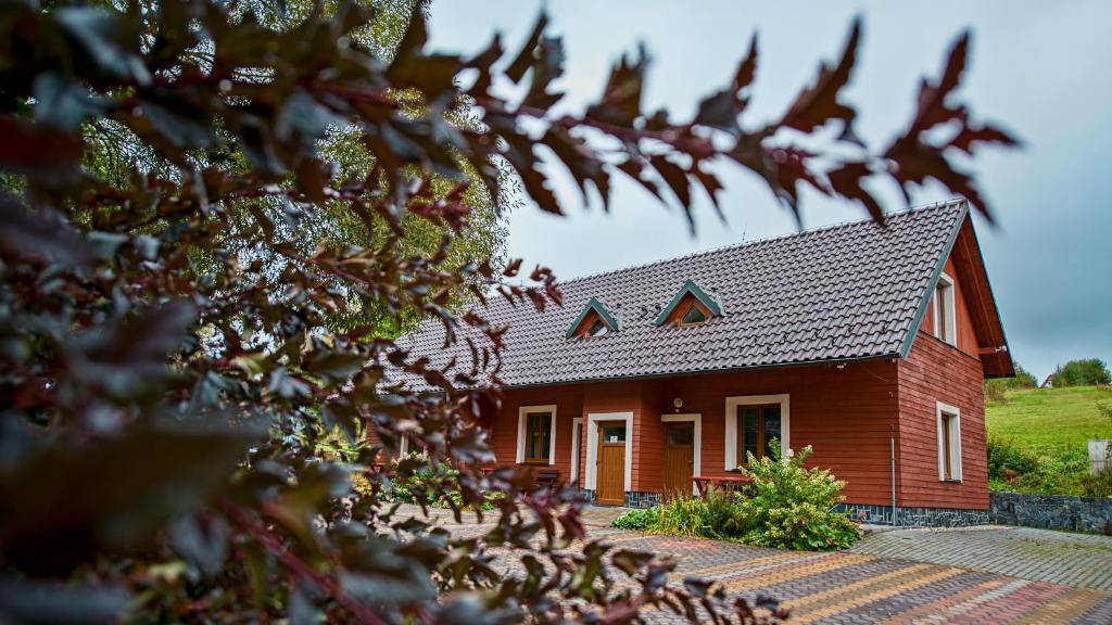 a red house with a black roof at Apartmány Pod Čerťákem in Dolní Moravice