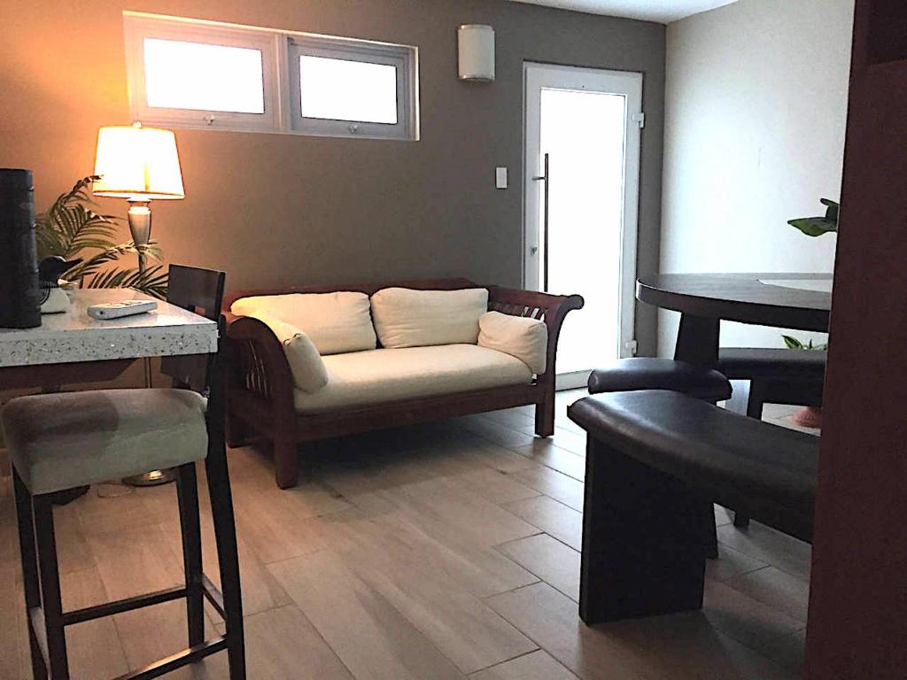 uma sala de estar com um sofá e uma mesa em SEGOVIA STUDIO UNITS em Carolina