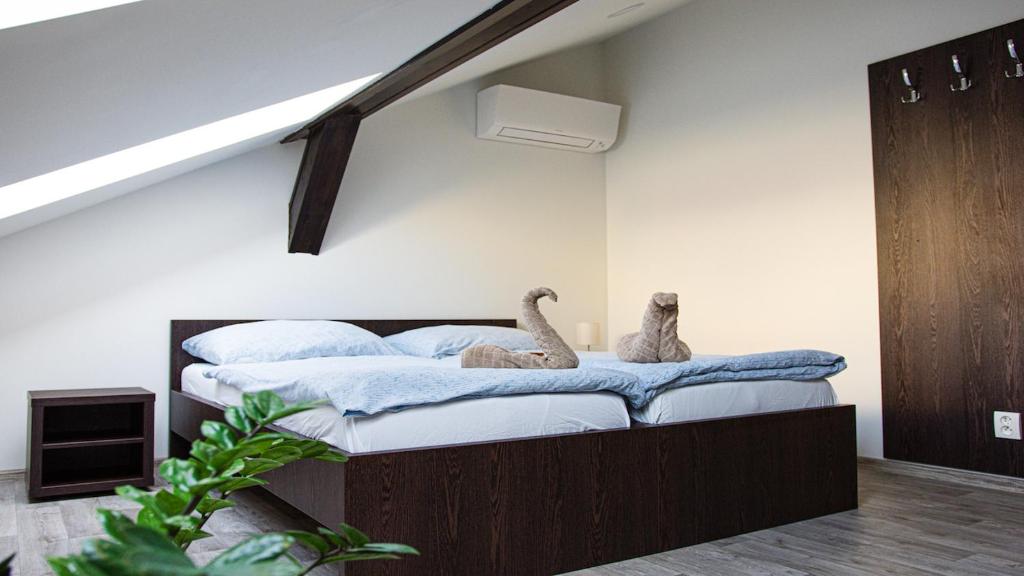 two stuffed animals sitting on a bed in a room at Penzion Poruba in Ostrava