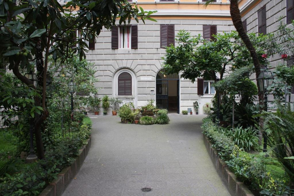 a courtyard of a building with trees and plants at B&B Sergio House in Rome