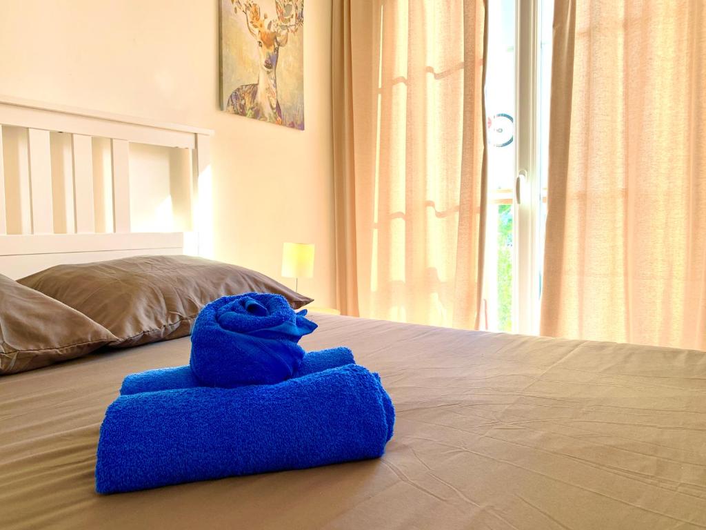 a blue stuffed animal sitting on top of a bed at JADE Appartement in Manosque