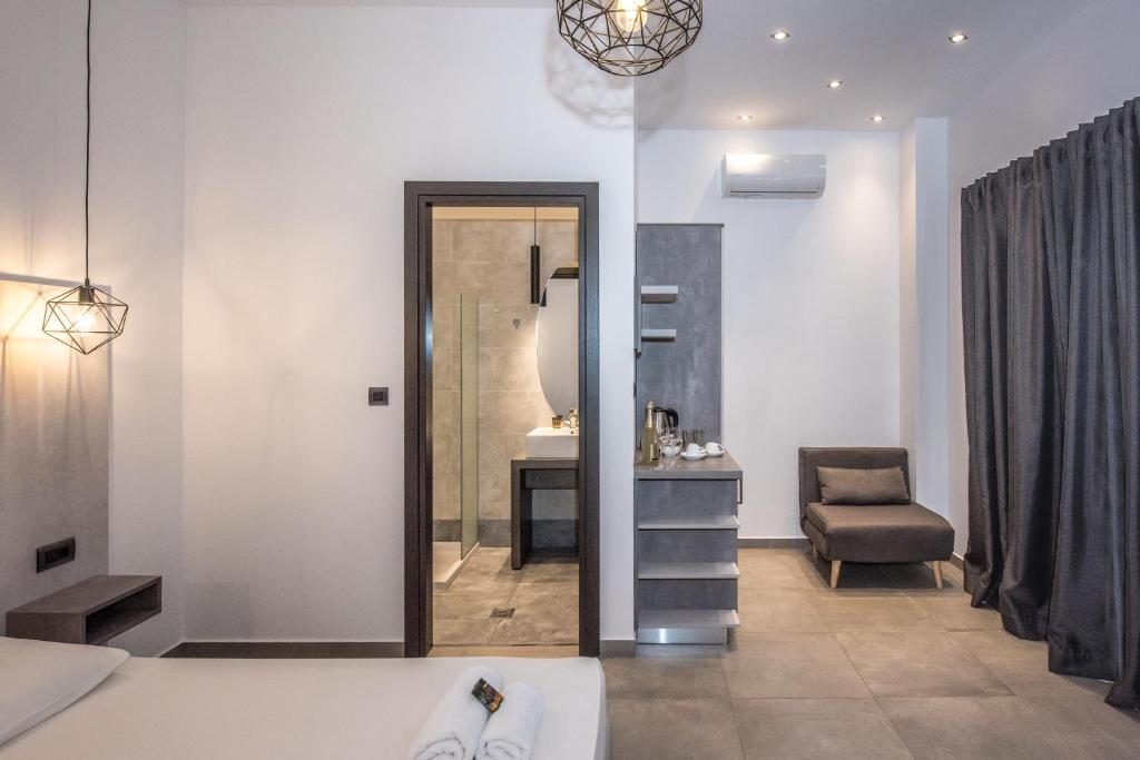 a bedroom with a bed and a chair and a mirror at Xasteria in Elafonisi