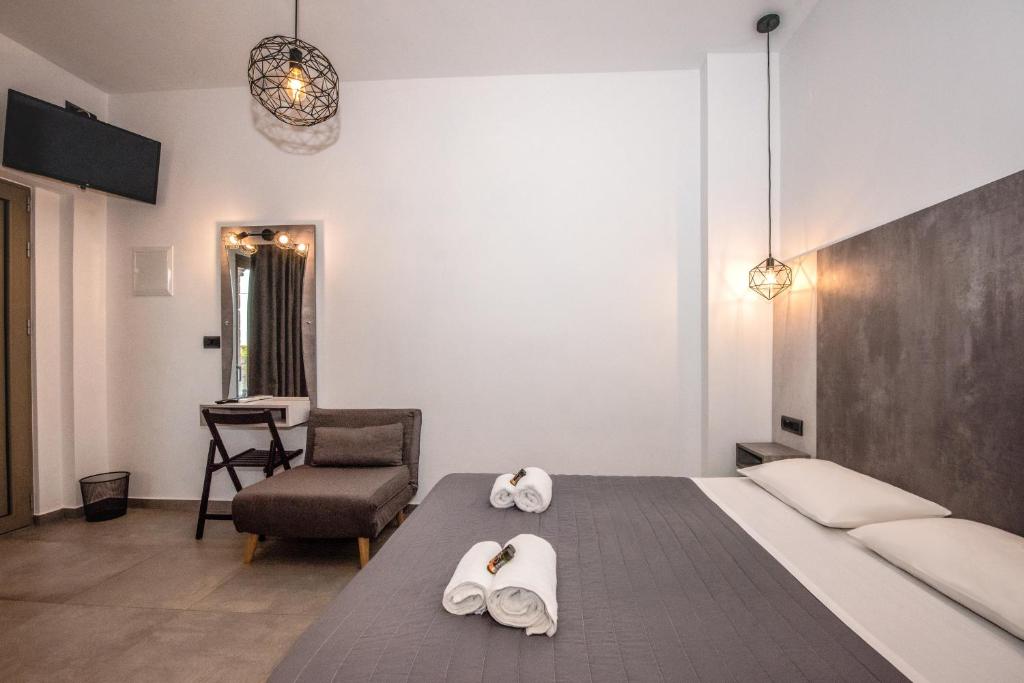 a bedroom with a bed with towels and a chair at Xasteria in Elafonisi