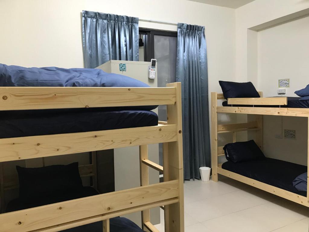 a room with three bunk beds in a room at Sam-Lin Hostel in Yujing