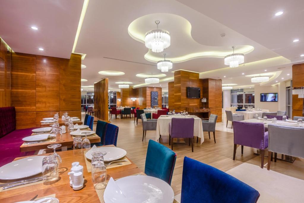 una sala da pranzo con tavoli e sedie blu di Ferdi Lilly a Ben ʼAknoûn