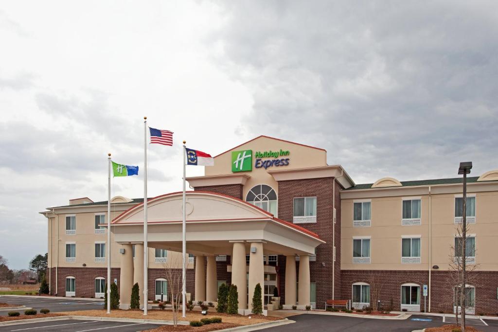 un hotel con dos banderas frente a un edificio en Holiday Inn Express Pembroke, an IHG Hotel, en Pembroke