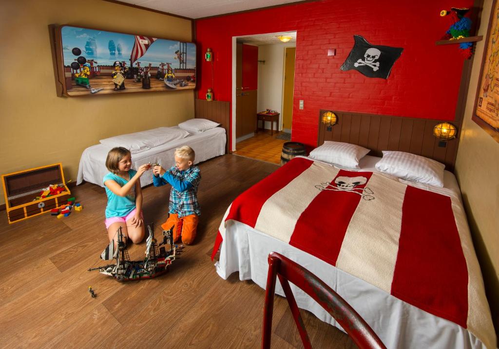 two children in a bedroom with two beds at LEGOLAND Pirates´ Inn Motel in Billund