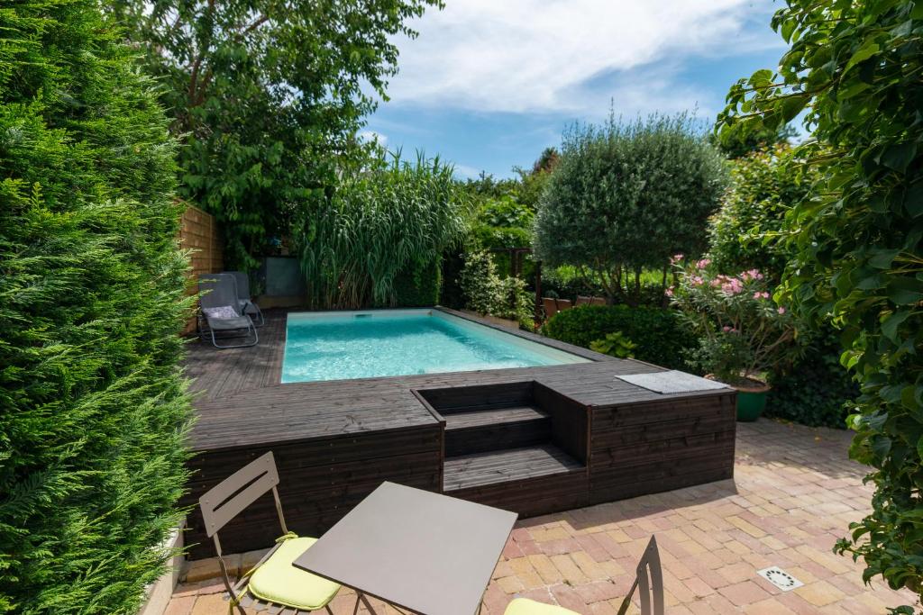 - une piscine dans un jardin avec une table et des chaises dans l'établissement Hibiscus House, à Carcassonne