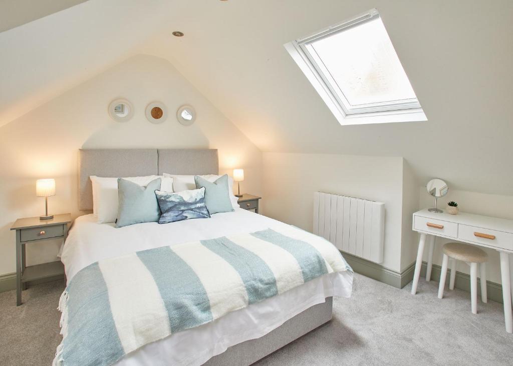 een slaapkamer met een groot bed en een dakraam bij Host & Stay - Threadneedle Cottage in Whitby