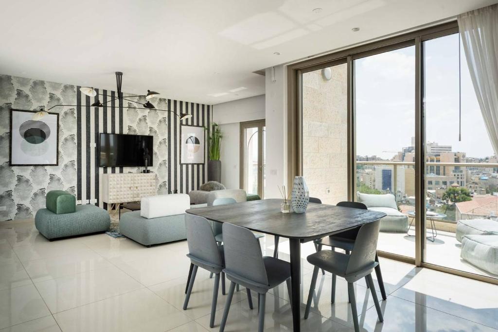 - un salon avec une table à manger et des chaises dans l'établissement Presidential Two-Bedroom Apartment With Terrace, à Jérusalem