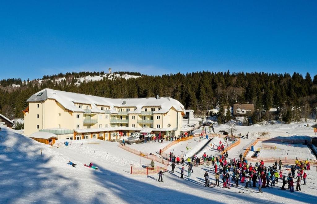 um grupo de pessoas em pé na neve em frente a um alojamento de esqui em Ferienresidenz Grafenmatt, Feldberg em Feldberg