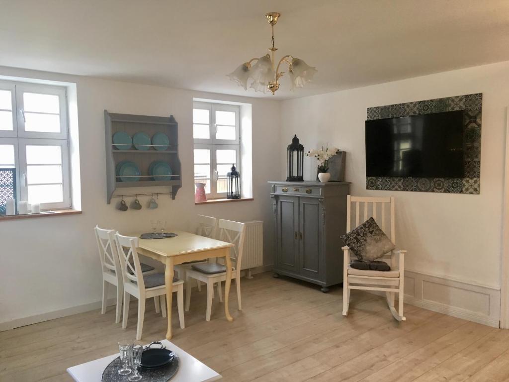 a dining room with a table and chairs and a tv at Freigeist Ferienwohnungen in Haßloch