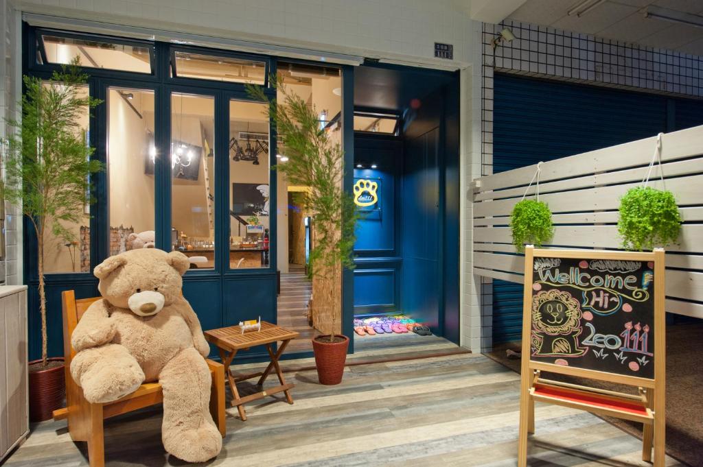 a teddy bear sitting on a chair outside a store at Leo 111/Arena Ruifeng in Kaohsiung