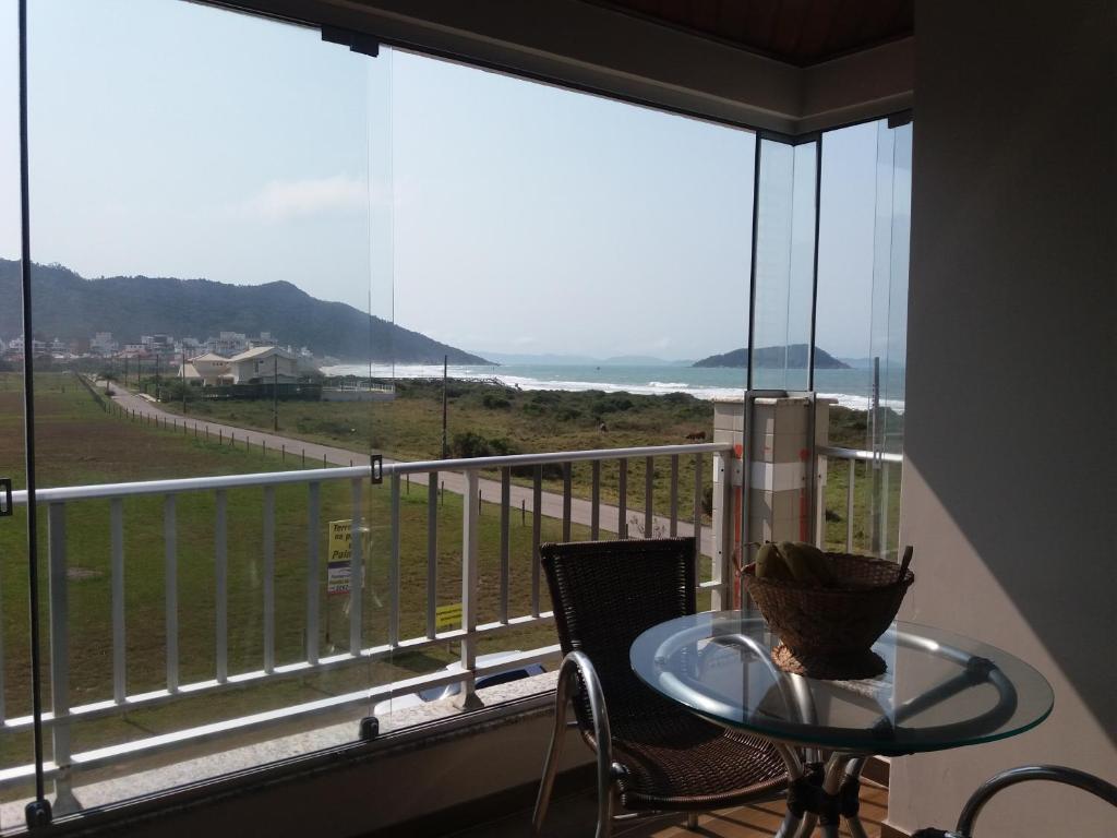 a balcony with a table and a view of the ocean at Ed. Praia de Palmas SC in Governador Celso Ramos
