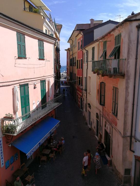 a group of people standing in an alley between buildings at Celle mare con posto auto coperto in Celle Ligure