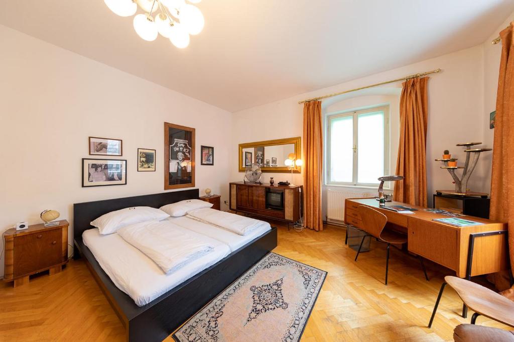 ein Schlafzimmer mit einem großen Bett und einem Schreibtisch in der Unterkunft Sixties Appartement in Graz