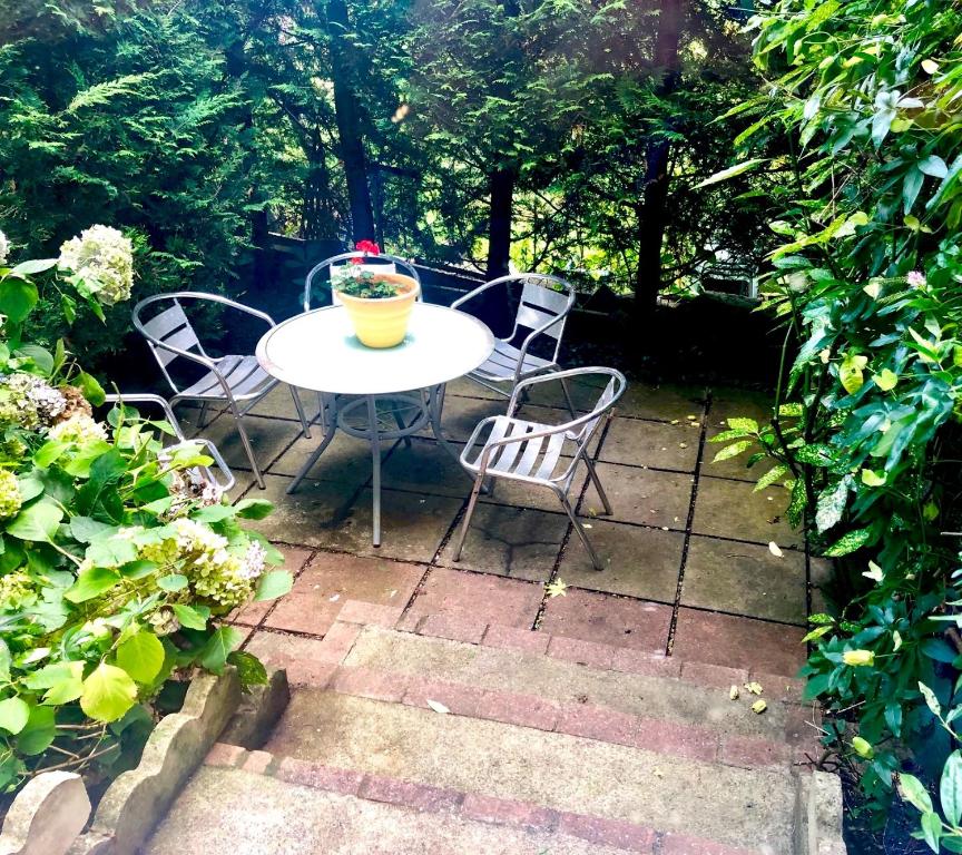 a table and chairs sitting on a patio at Lauras Townhouse Apartments Grand Garden Apartment in Bath