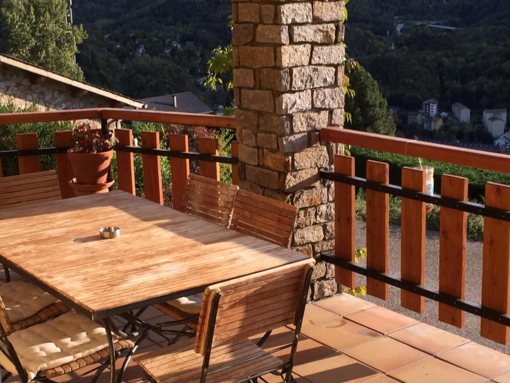 a wooden deck with a wooden table and chairs at La soulane in Ax-les-Thermes