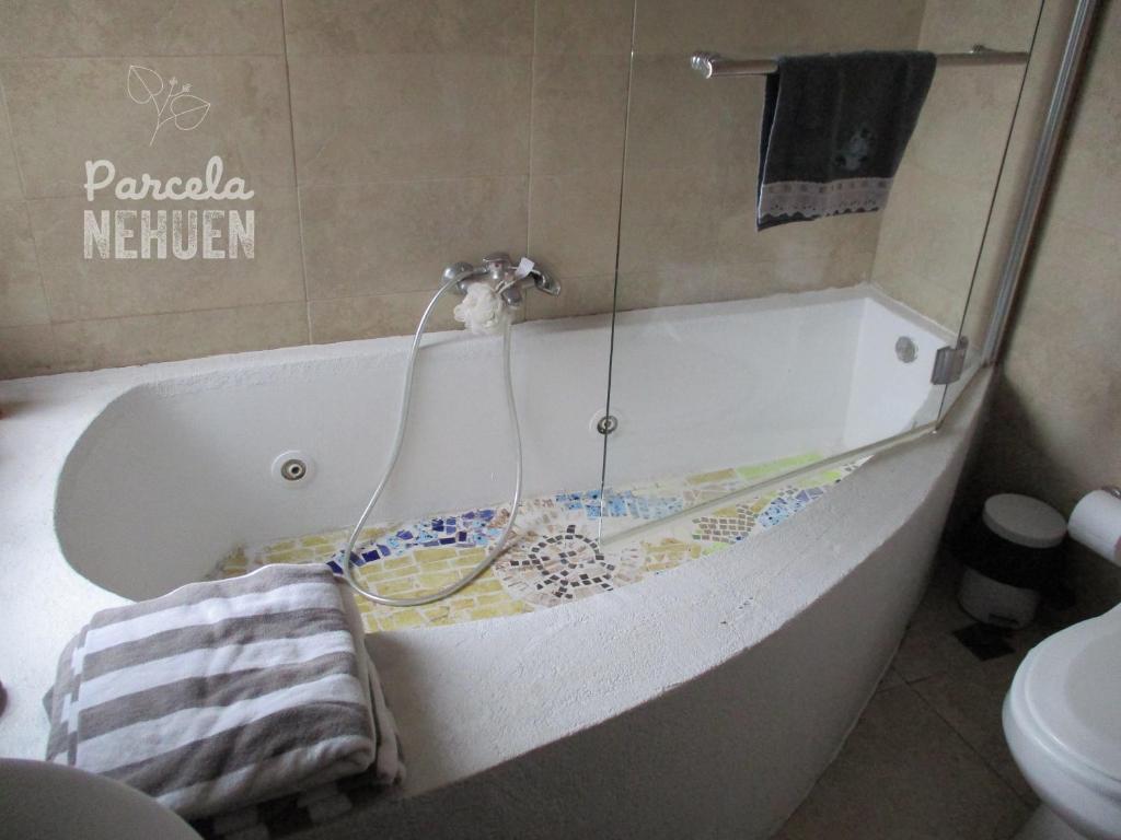 a bath tub with a faucet in a bathroom at Parcela 9 Nehuen in Talagante