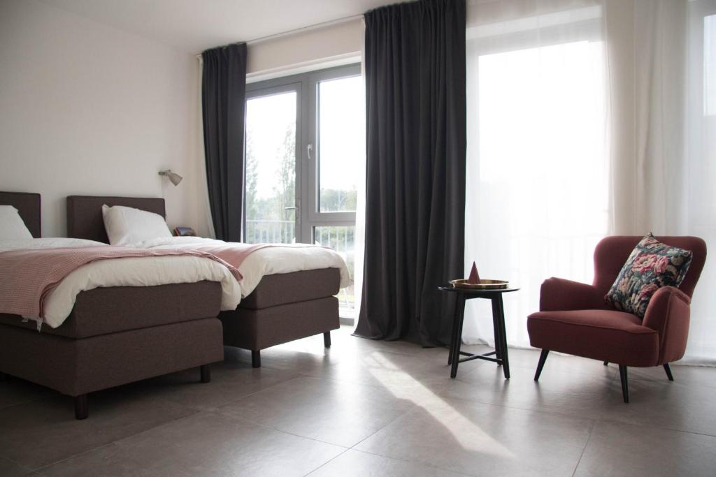um quarto com uma cama, uma cadeira e uma janela em B&B Mondriaan em Amsterdã